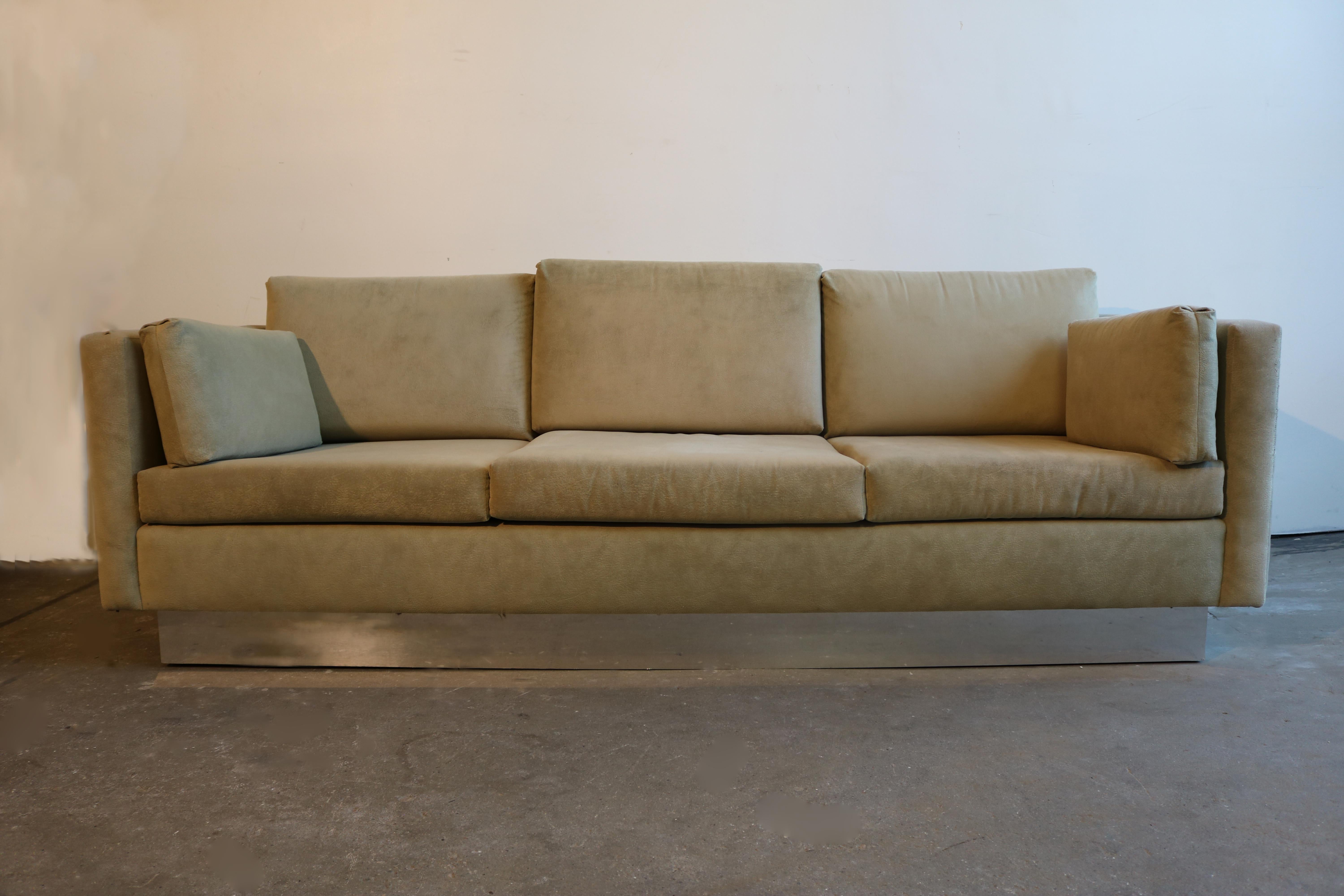This textured suede light grey three-seat sofa rests on a chrome base, with two side cushions. 
The frame's height is 24.5.
