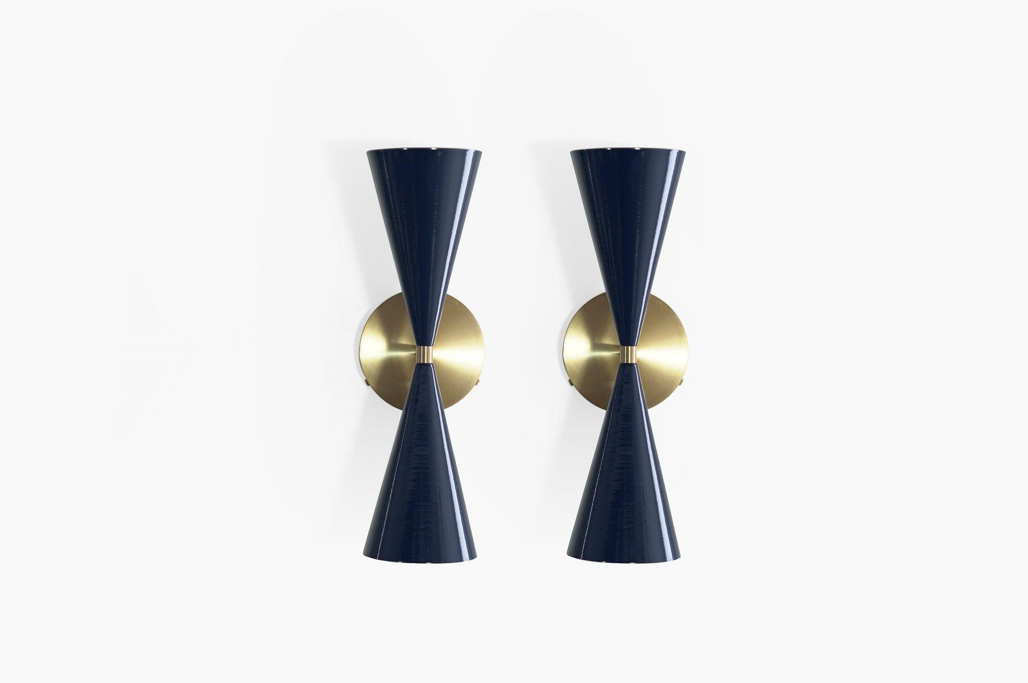 Introducing the Tuxedo Wall Sconce: a stunning embodiment of French and Italian Mid-Century Modernism. With its handsome and transitional design, this sconce is perfectly scaled to enhance various spaces in your home. Whether it's adding charm to a