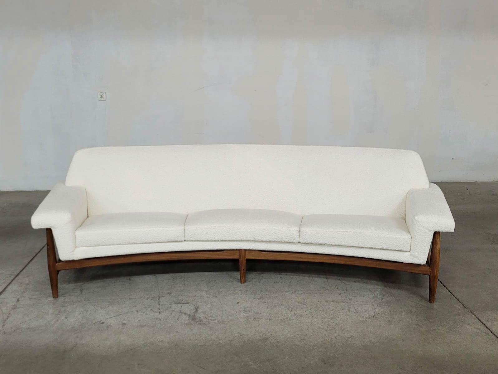 The Johannes Andersen-designed sofa, manufactured by AB Trensums Fåtöljfabrik from the 1950s to the 1970s. Crafted from teak and upholstered in a classic bouclette white fabric, this vintage piece boasts a fusion of timeless elegance and