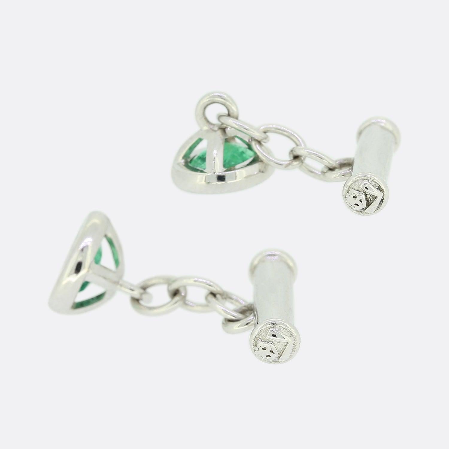 Si tratta di un paio di gemelli in oro bianco 18ct di eccezionale fattura. Ogni gemello ospita uno smeraldo naturale ovale in un'incastonatura a sfregamento e una catena che conduce al retro della barra. La barra è stata intagliata con il logo TVJ