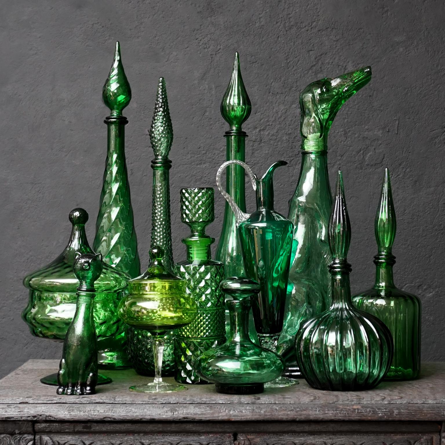 Spectacular set of twelve 1960s green Italian Empoli pressed and blown glass. Five genie bottles, a blown glass pitcher in the prettiest colour green, a whiskey decanter, a large dog shaped bottle and a tiny cute little cate shaped one. Two very