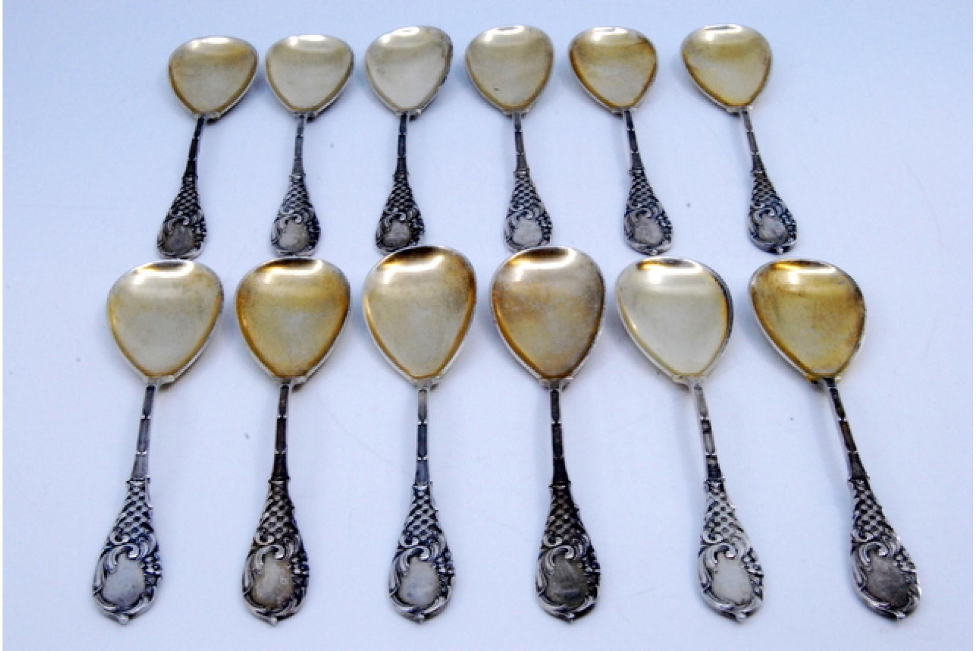 Description: Set of twelve coffee spoons with golden shells and reliefs on the handles with monogram cards. Metal: Silver. Origin: German. Brand: Unknown. Weight: 197.62 grams (Set of twelve spoons). Dimensions: 12x2.8cm. Content: 800/1000. Assay