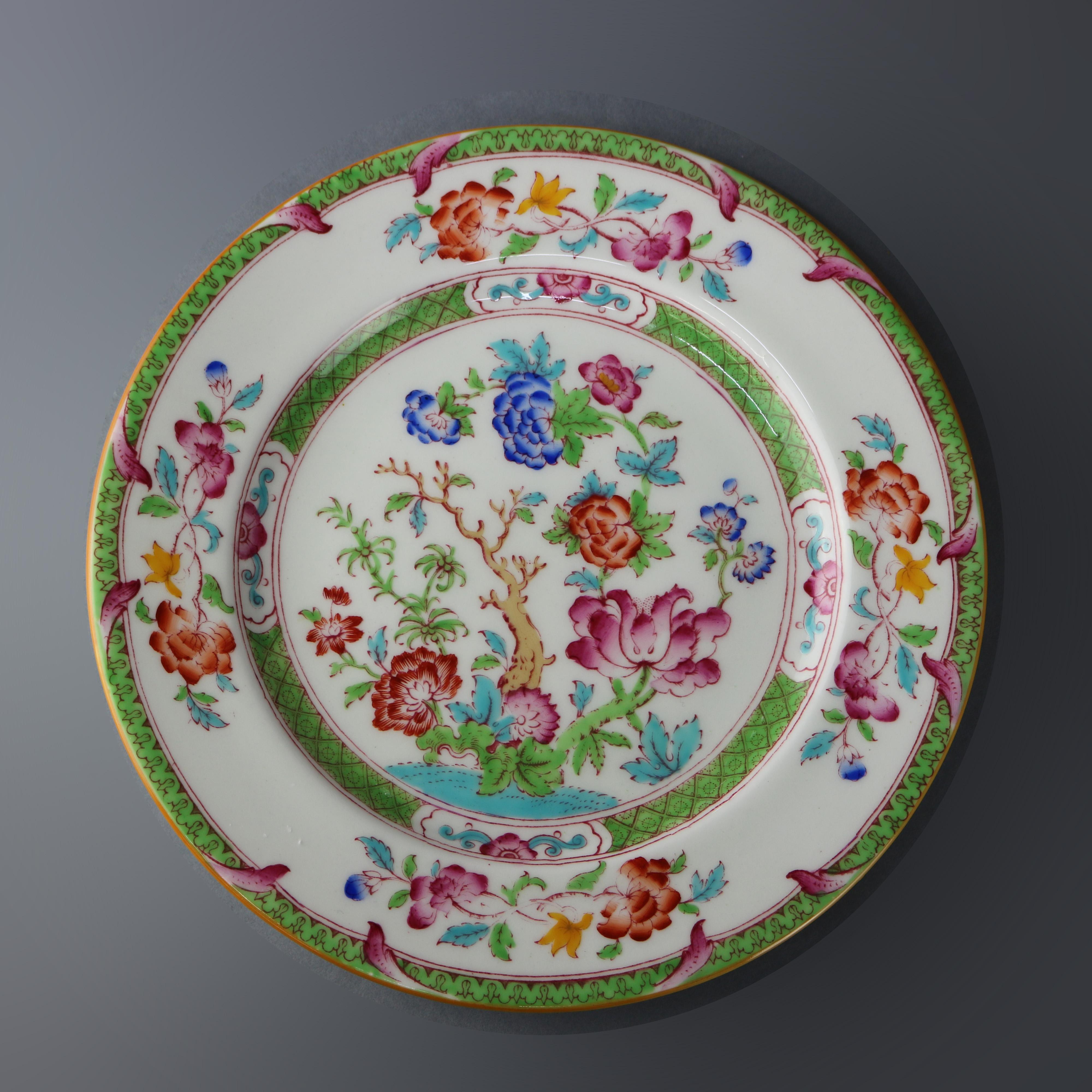 A vintage set of twelve fine china porcelain salad plates by Cauldon, England offer hand painted floral garden decoration with gilt highlights, elements of Aesthetic Movement, en verso maker stamp as photographed, circa 1940.

Measures: 8.75
