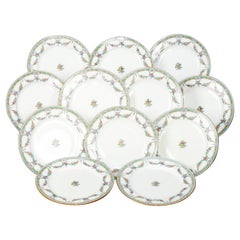 Douze assiettes plates anglaises Mintons en porcelaine fine de Chine à guirlande florale