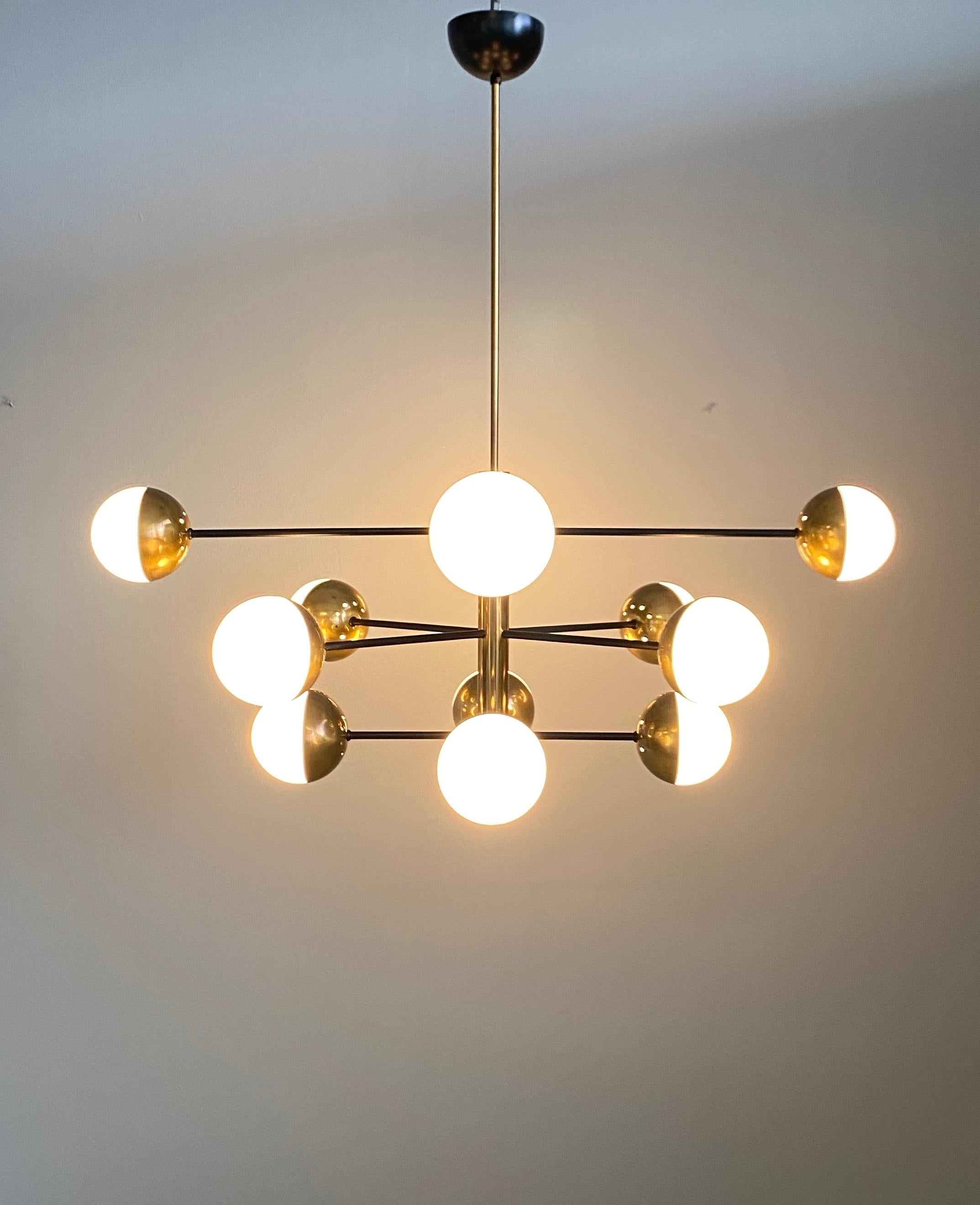 Large midcentury chandelier in the manner of Stilnovo composed of twelve-glass globes and brass a frame.