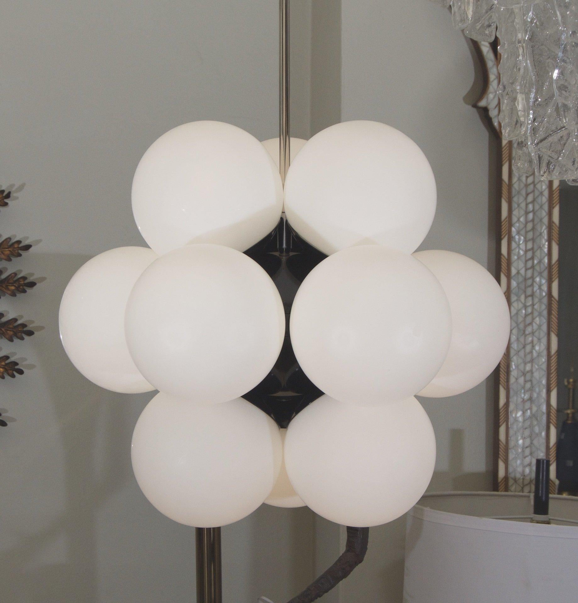 Kaiser Leuchten
Germany, 1970s

Gorgeous Kaiser chandelier with a molecular structure, much more dense visually than comparable Sputnik form chandeliers. Gloss black enamel central body is surround by 12 closely attached opal globes.

Takes 12