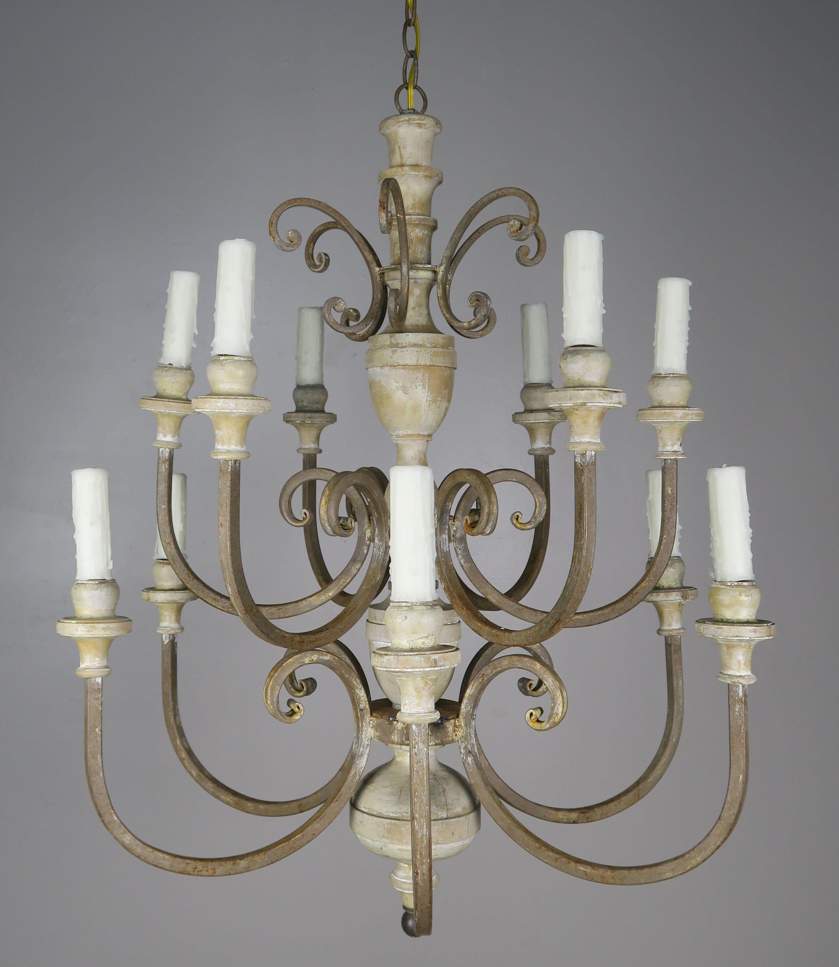 Twelve-light, two-tier Italian wrought iron and wood chandelier with a beautiful weathered finish. The fixture has been newly rewired with drip wax candle covers and is ready to install with chain and canopy.