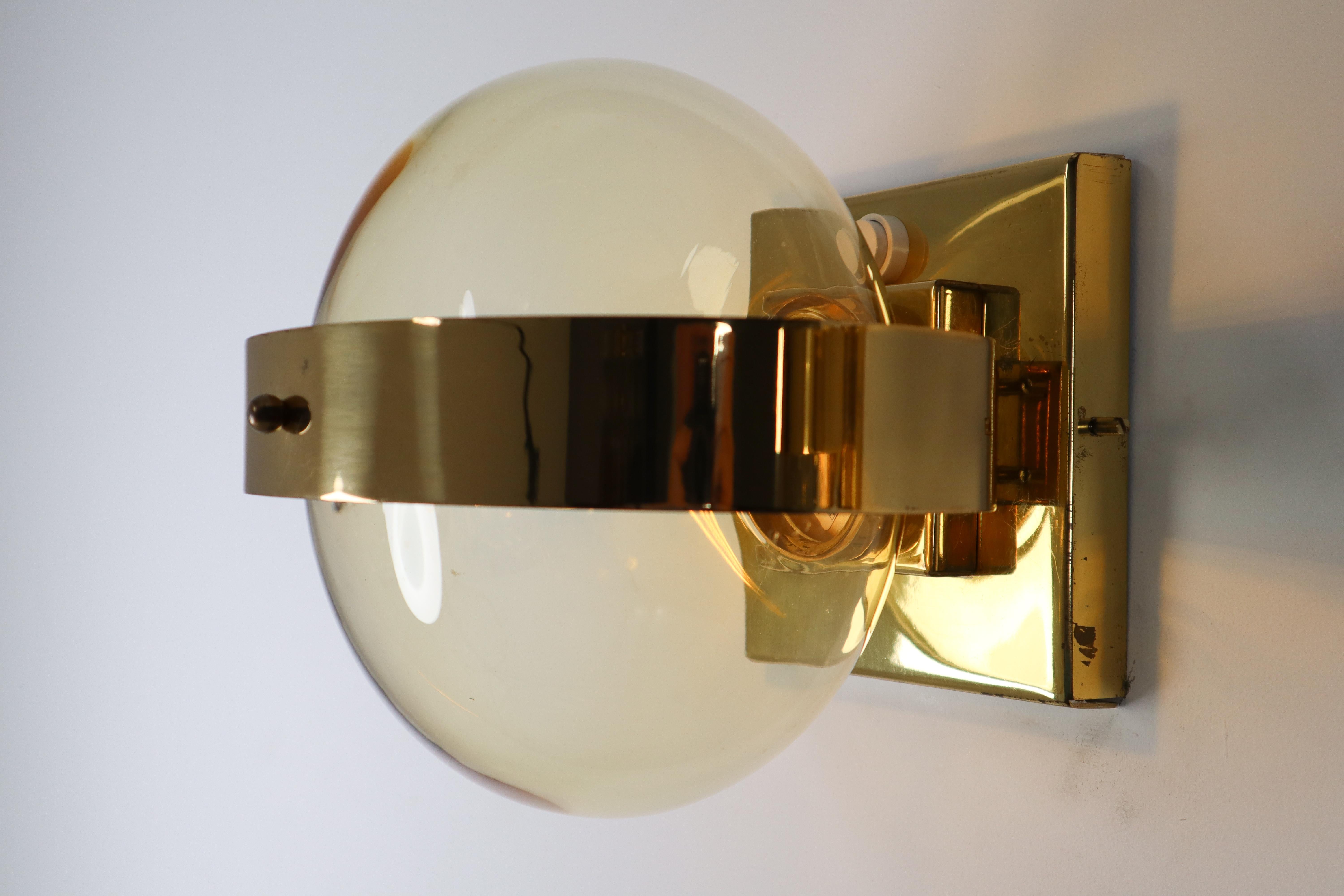 Set of 12 wall sconces - wall lights with square brass backplate and hand blowed glass globe. The pleasant light it spreads is very atmospheric, these wall scones will contribute to a luxurious character of the (hotel-bar) interior. Perfect original