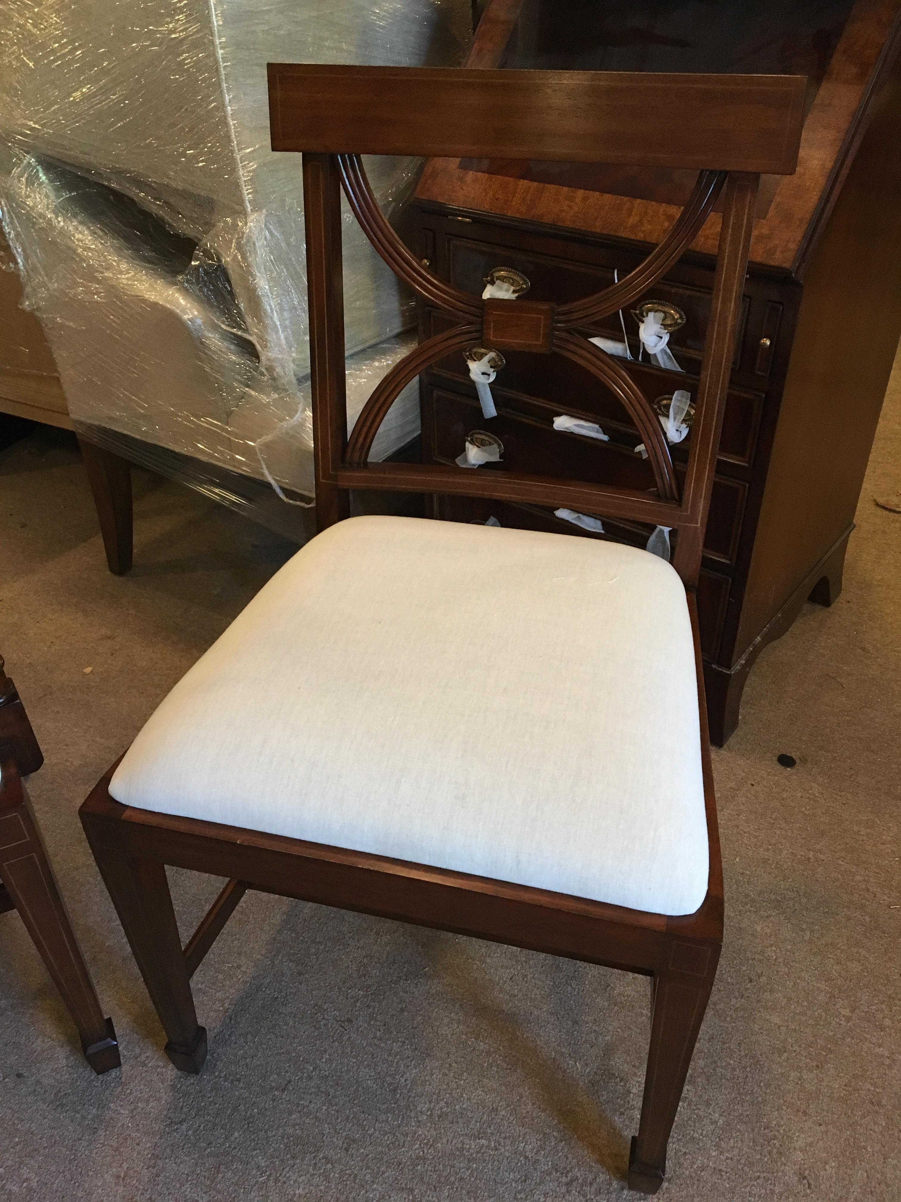 These are new traditional mahogany dining chairs. Their design was inspired by the Adams Style Dining Chairs from the Regency period. They feature classic Adams style Inlays and  square tapered legs. This is a set of twelve chairs (2 arms and 10