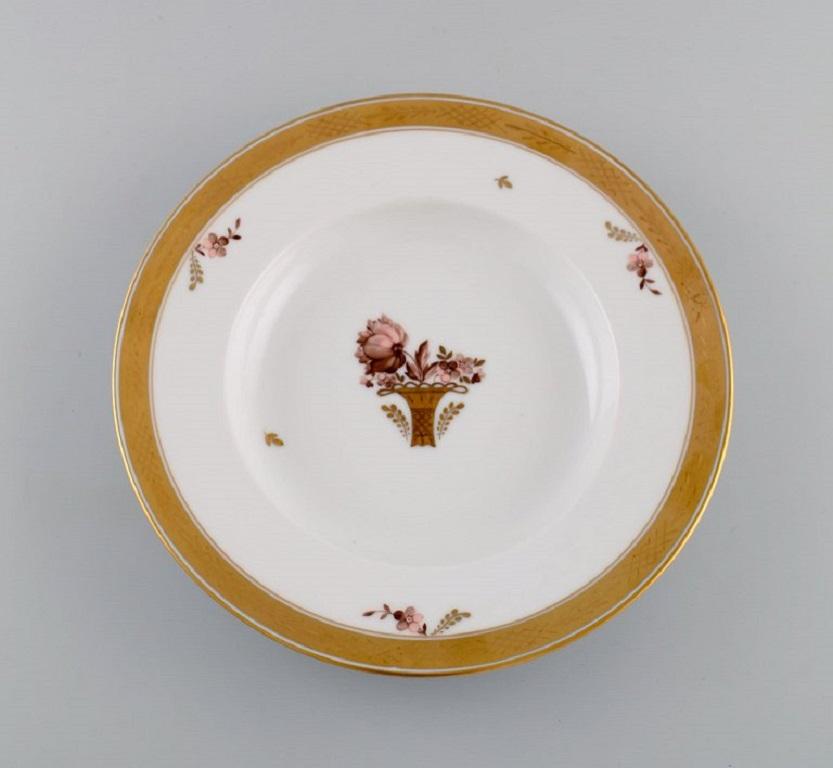 Twelve Royal Copenhagen Gold Basket deep plates in porcelain with flowers and gold decoration. Model number 595/10515. 
Early 20th century.
Measures: 25.5 x 4 cm.
In excellent condition.
Stamped.
1st factory quality.