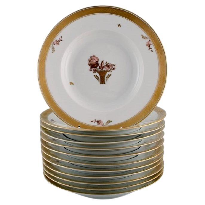 Douze assiettes profondes en forme de panier Royal Copenhagen en porcelaine avec fleurs et or