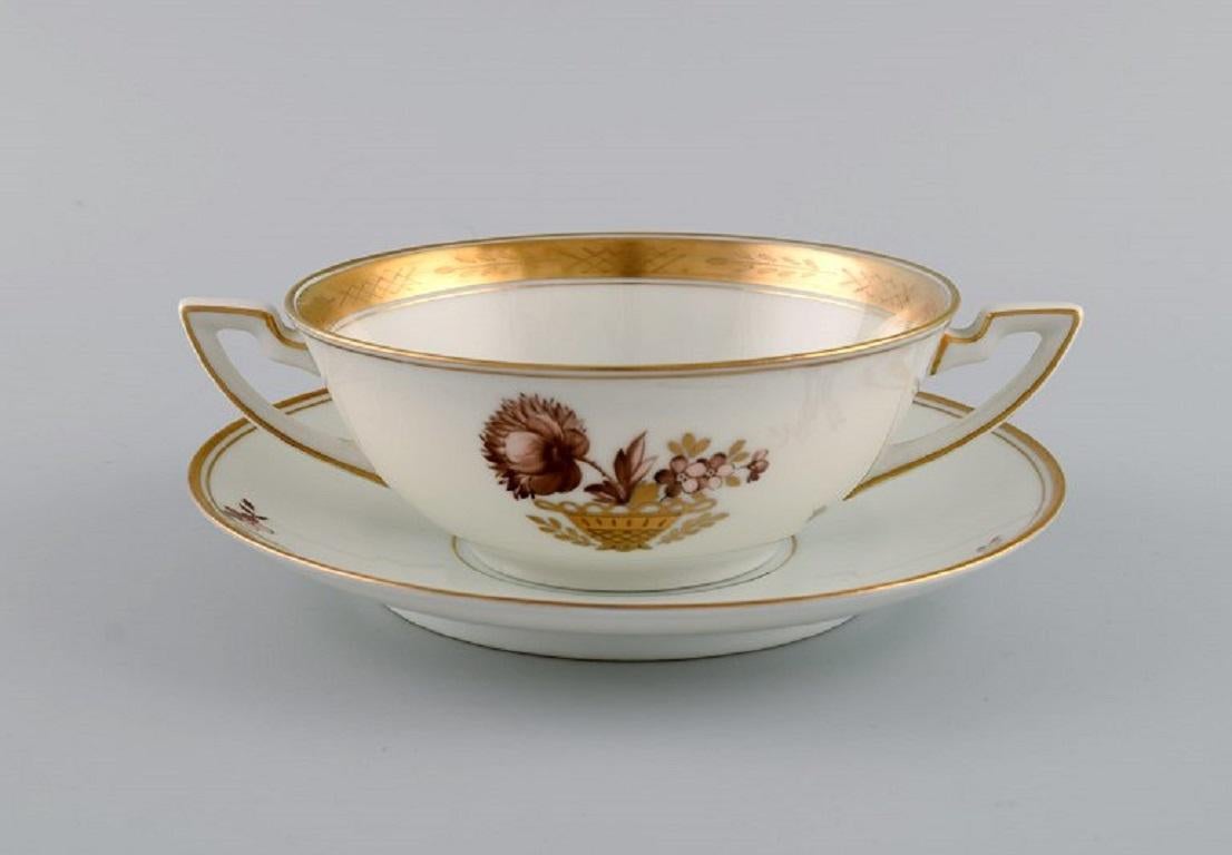 Twelve Royal Copenhagen Golden Basket bouillon cups with saucers.
Model number 595/9571. 
Dated 1889-1922.
The cup measures: 13 x 5 cm.
Saucer diameter: 17 cm.
In excellent condition.
Stamped.
1st factory quality.