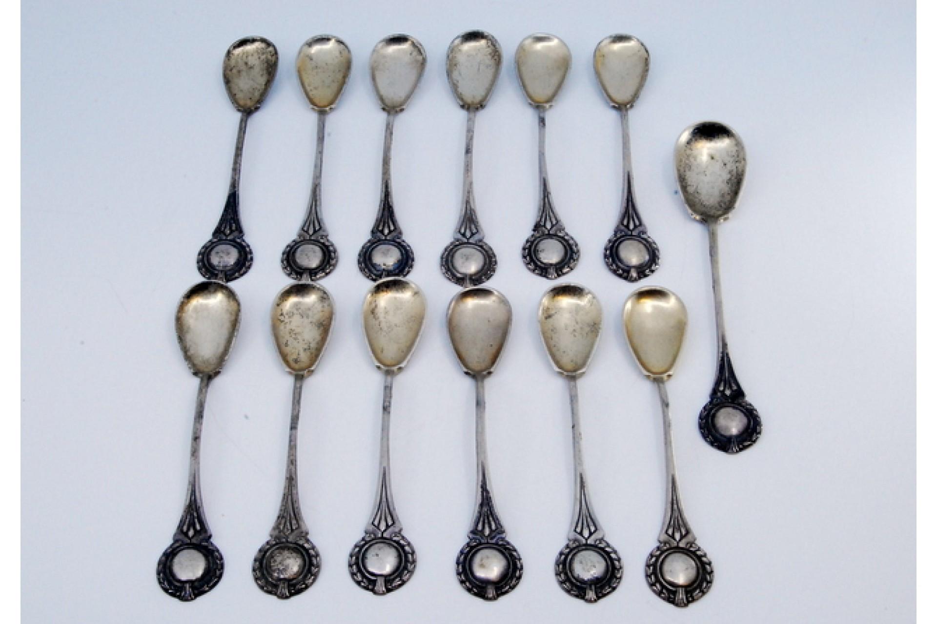 Description: Set of twelve coffee spoons and sugar shovel in silver with monogram cards on the handles. Metal: Silver. Origin: Portuguese. Brand: Cabeça de escravo. Weight: 233.69 grams (Set of twelve spoons and shovel). Dimensions: 12.3x2.2cm.