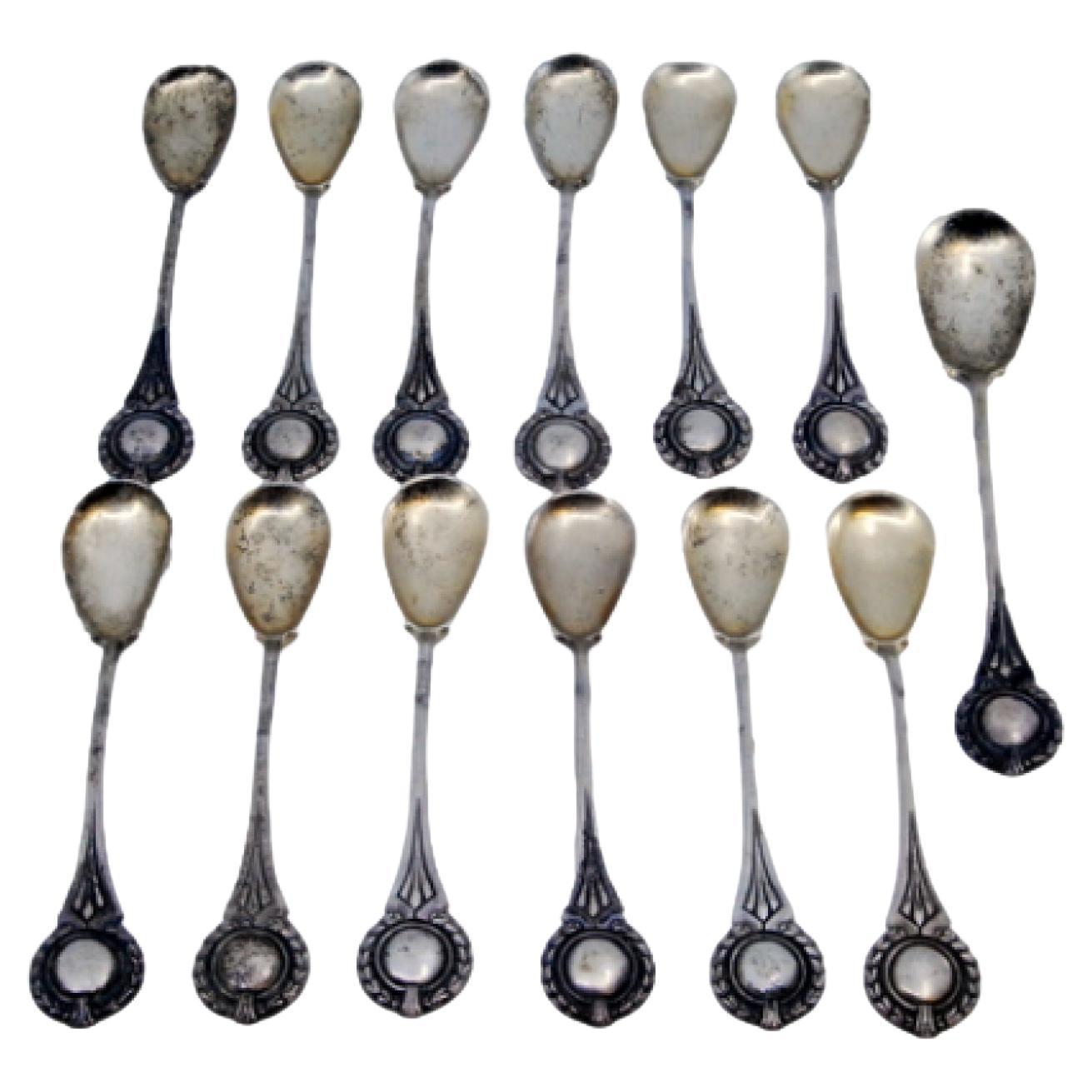 Twelve silver coffee spoons and sugar scoop with monogrammed handles