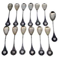 Twelve silver coffee spoons and sugar scoop with monogrammed handles Twelve silver coffee spoons and sugar scoop with monogrammed handles