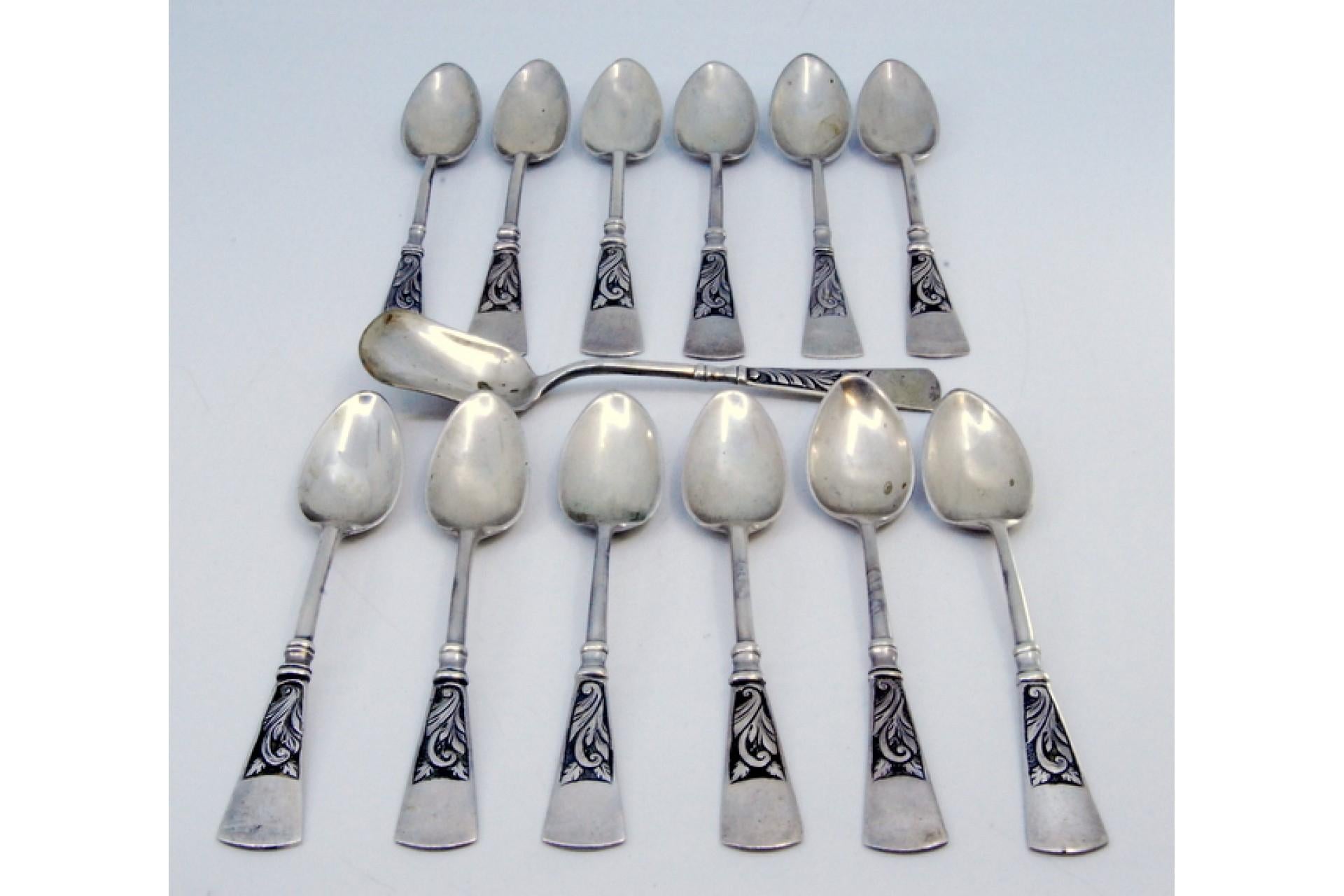 Description: Set of twelve coffee spoons and sugar shovel in silver with reliefs on the patinated handles. Metal: Silver. Origin: Portuguese. Brand: javali II Title. Weight: 258.39 grams (Set of twelve spoons and shovel). Dimensions: Shovel -