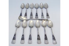 Twelve silver coffee spoons and sugar shovel with patinated relief handles
