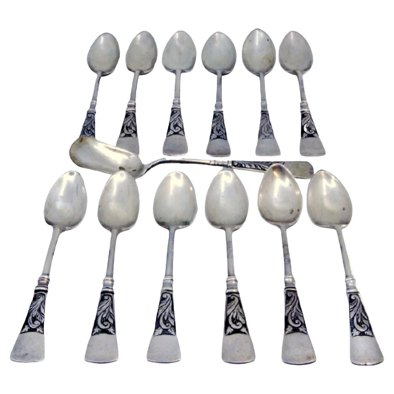 Twelve silver coffee spoons and sugar shovel with patinated relief handles