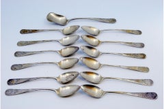 Twelve silver coffee spoons and sugar shovel with shell engravings