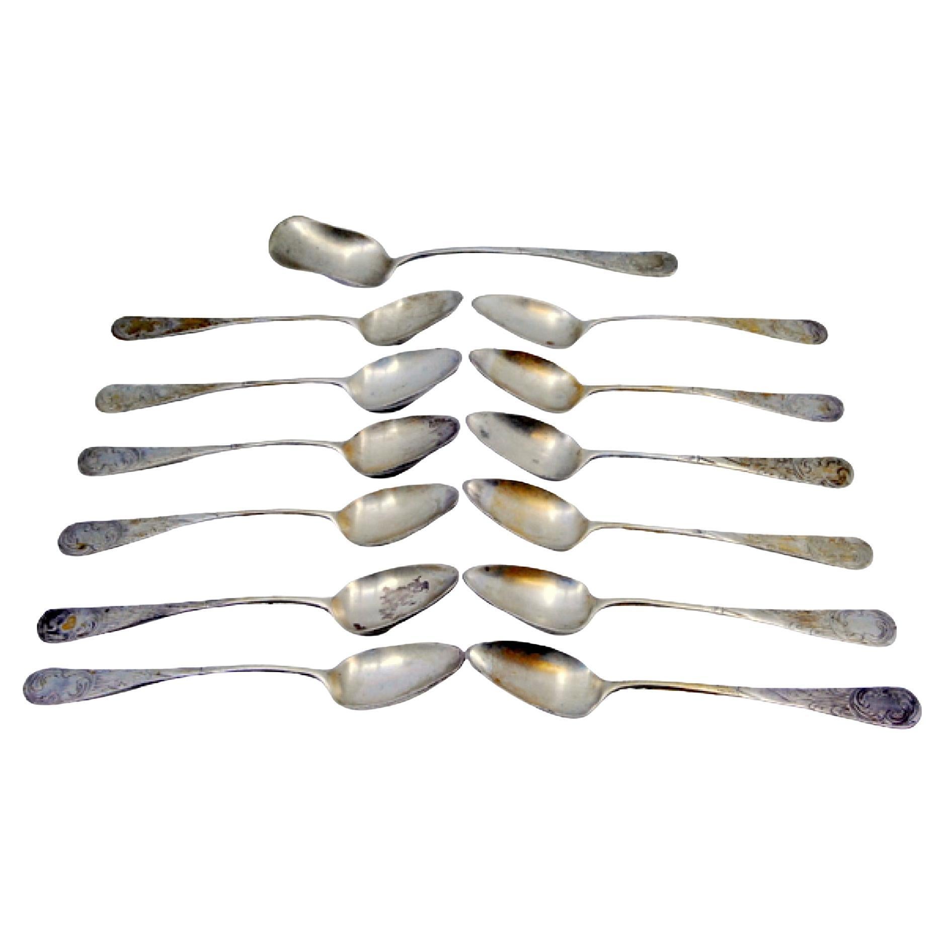 Twelve silver coffee spoons and sugar shovel with shell engravings