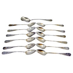 Twelve silver coffee spoons and sugar shovel with shell engravings
