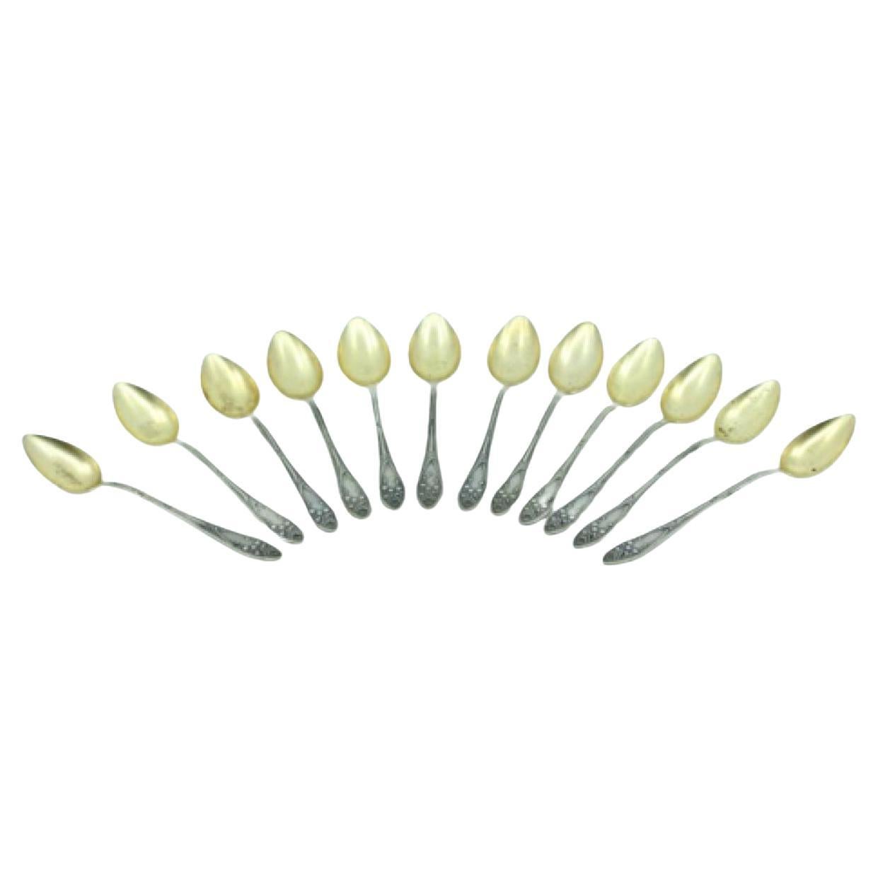 Twelve silver coffee spoons with gilt shells and raised cartouches For Sale