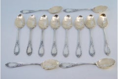 Twelve silver ice cream scoops with gilt engraved shells and raised handles