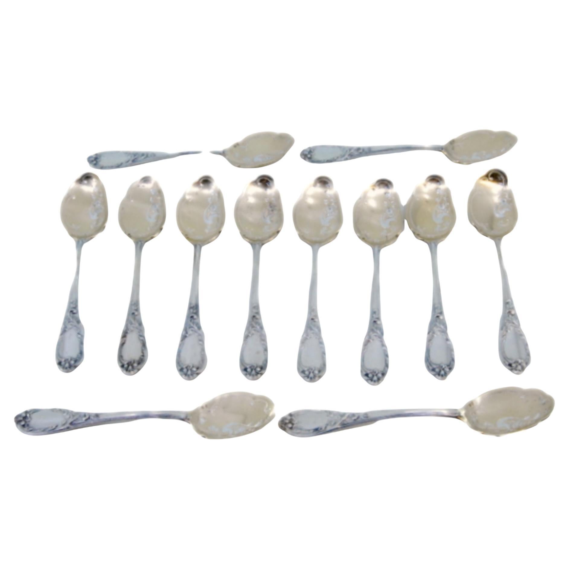 Twelve silver ice cream scoops with gilt engraved shells and raised handles