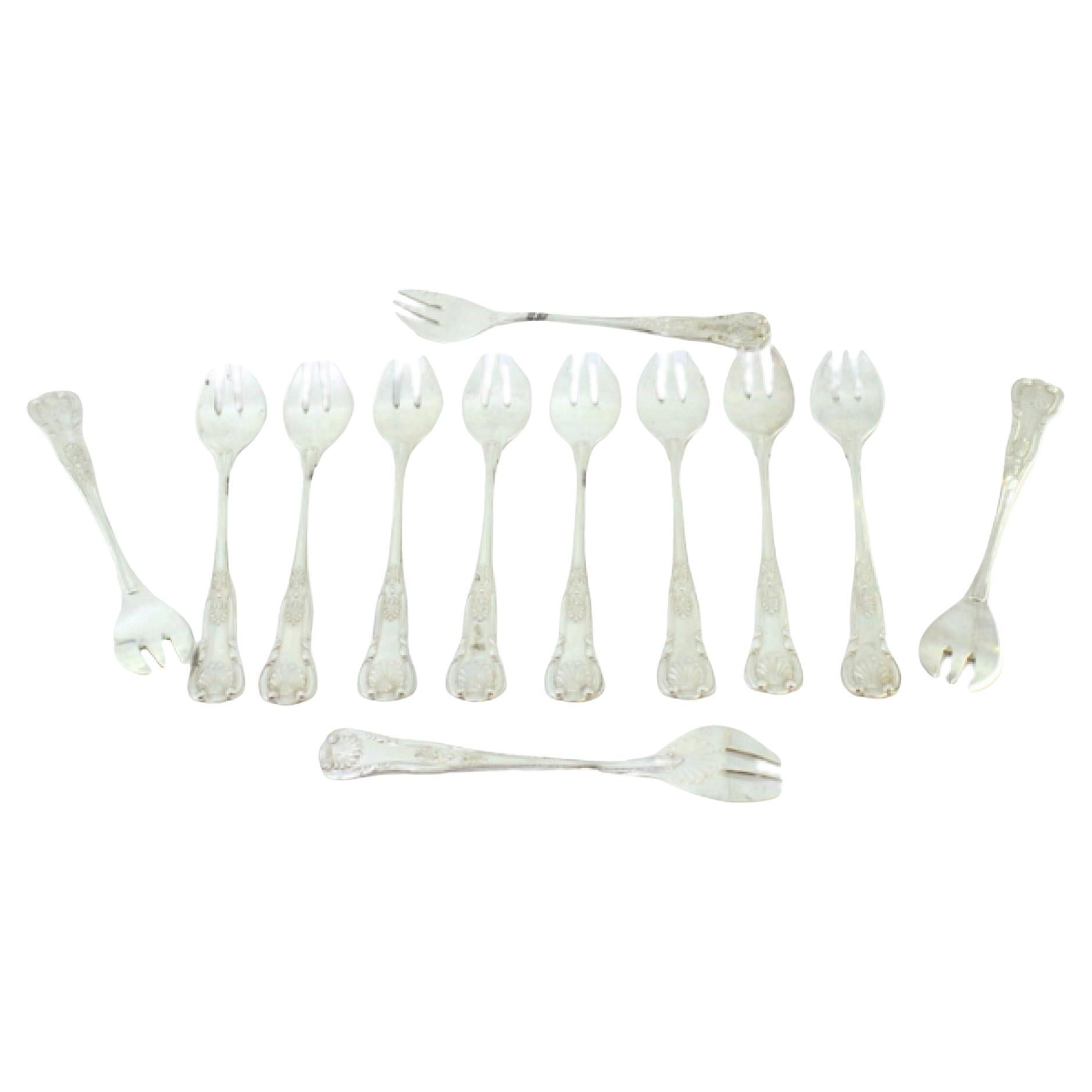Twelve silver oyster forks with exposed and shell-grooved handles