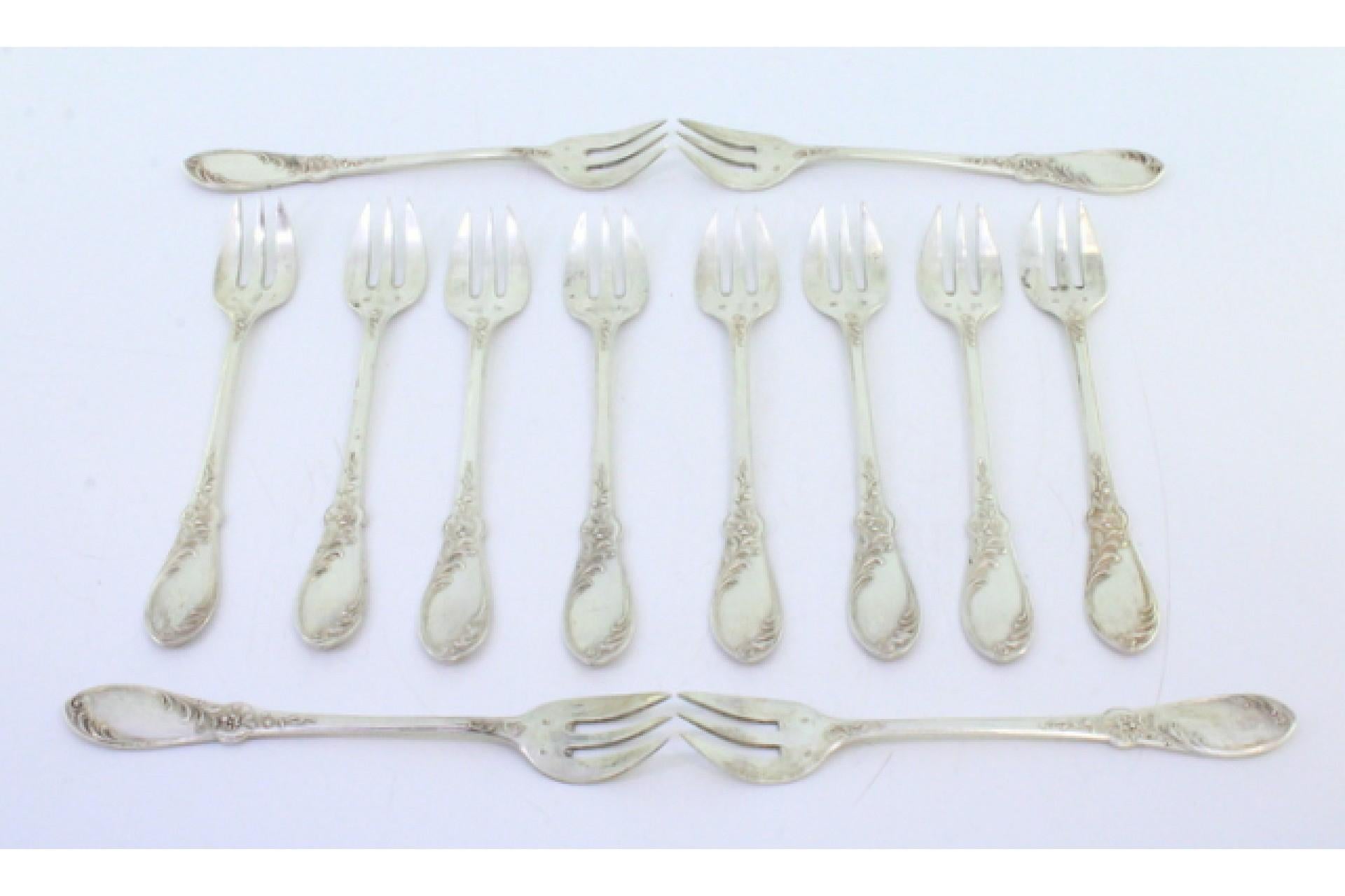 Description: Set of twelve silver oyster forks with reliefs involving monogram cards and three tines. Metal: Silver. Origin: European. Brand: Unknown. Weight: 303.81 grams (Set of twelve forks). Dimensions: 29.2cmx23.7cm. Content: 925/1000. Assay