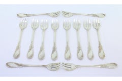 Twelve silver oyster forks with reliefs and monogrammed three-prong design