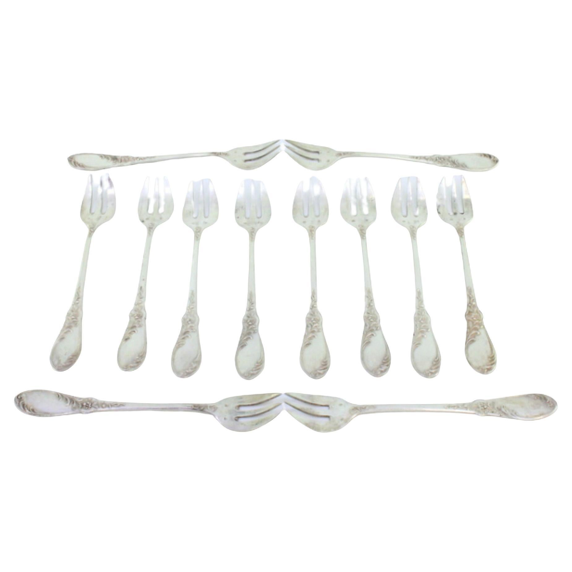 Twelve silver oyster forks with reliefs and monogrammed three-prong design
