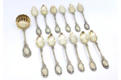 Twelve silver teaspoons and ladle with reliefs and monogrammed handles