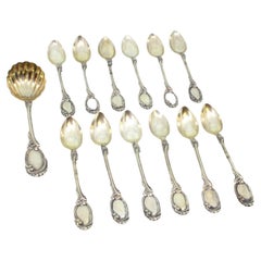 Twelve silver teaspoons and ladle with reliefs and monogrammed handles