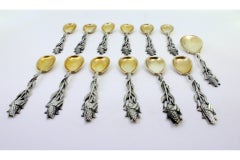 Twelve silver teaspoons and sugar shovel with corn-cob reliefs and gilt shells