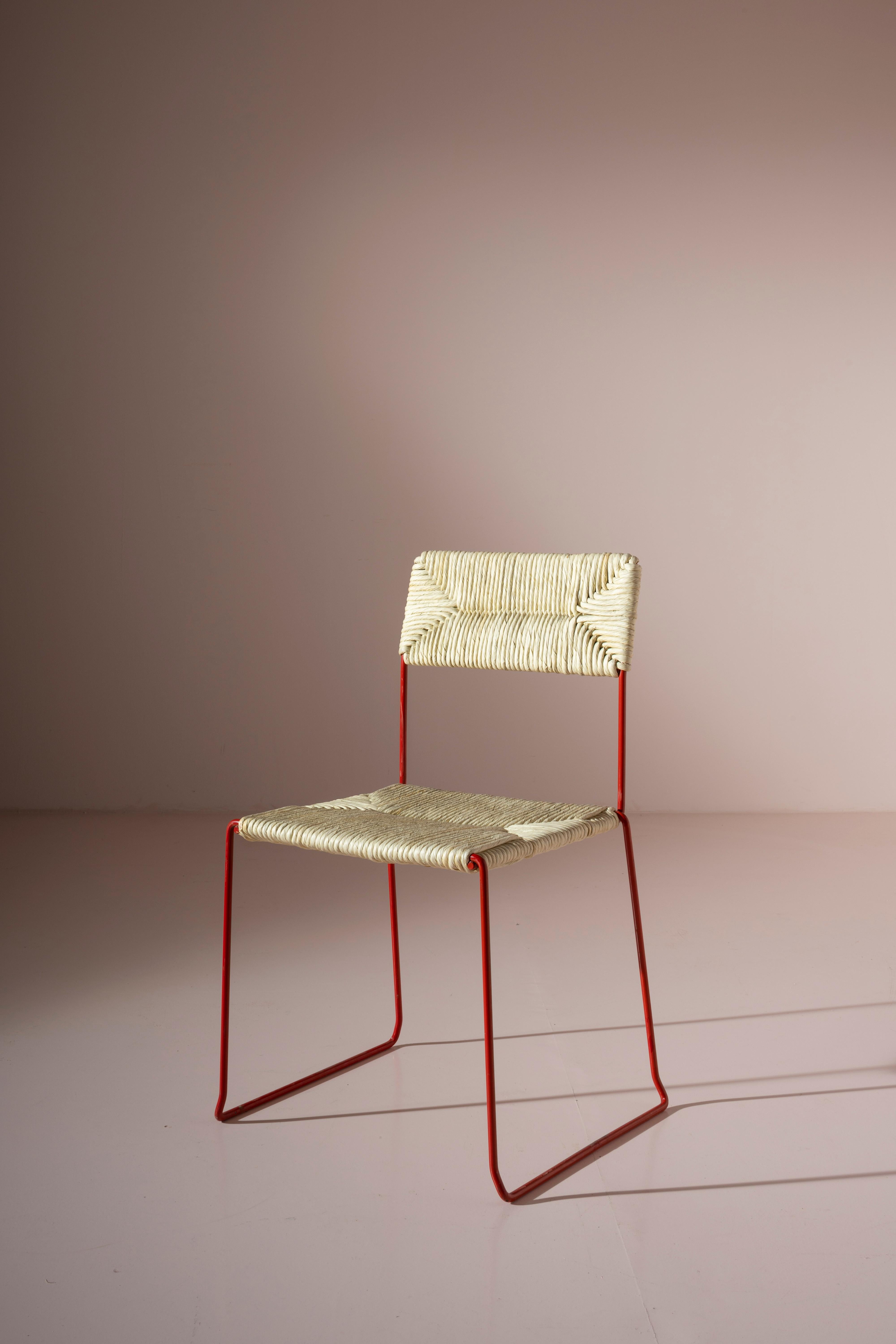 Con un diseño minimalista que hace guiños al estilo industrial, estas sillas francesas de los años 80 destacan por su sencillez. Una varilla de metal rojo parece correr de un lado a otro, dando forma al volumen de un asiento multifuncional, ligero y