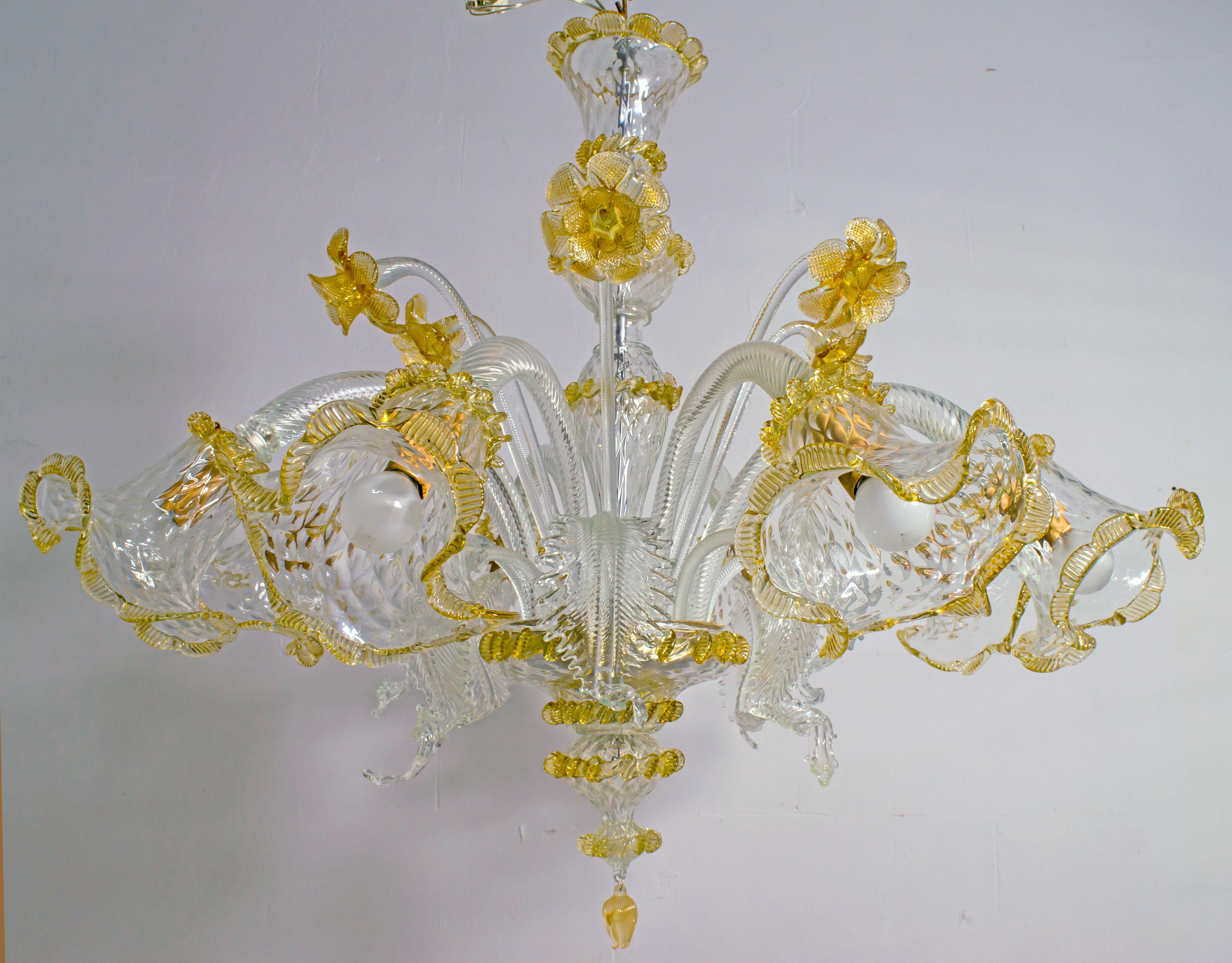 An elegant eight-light chandelier in Murano glass of transparent color and sophisticated antique gold finish. With a centered bulbous column that emits branches and flowers and finely cuts the Murano glass leaves.

Ca'Rezzonico is the name of a