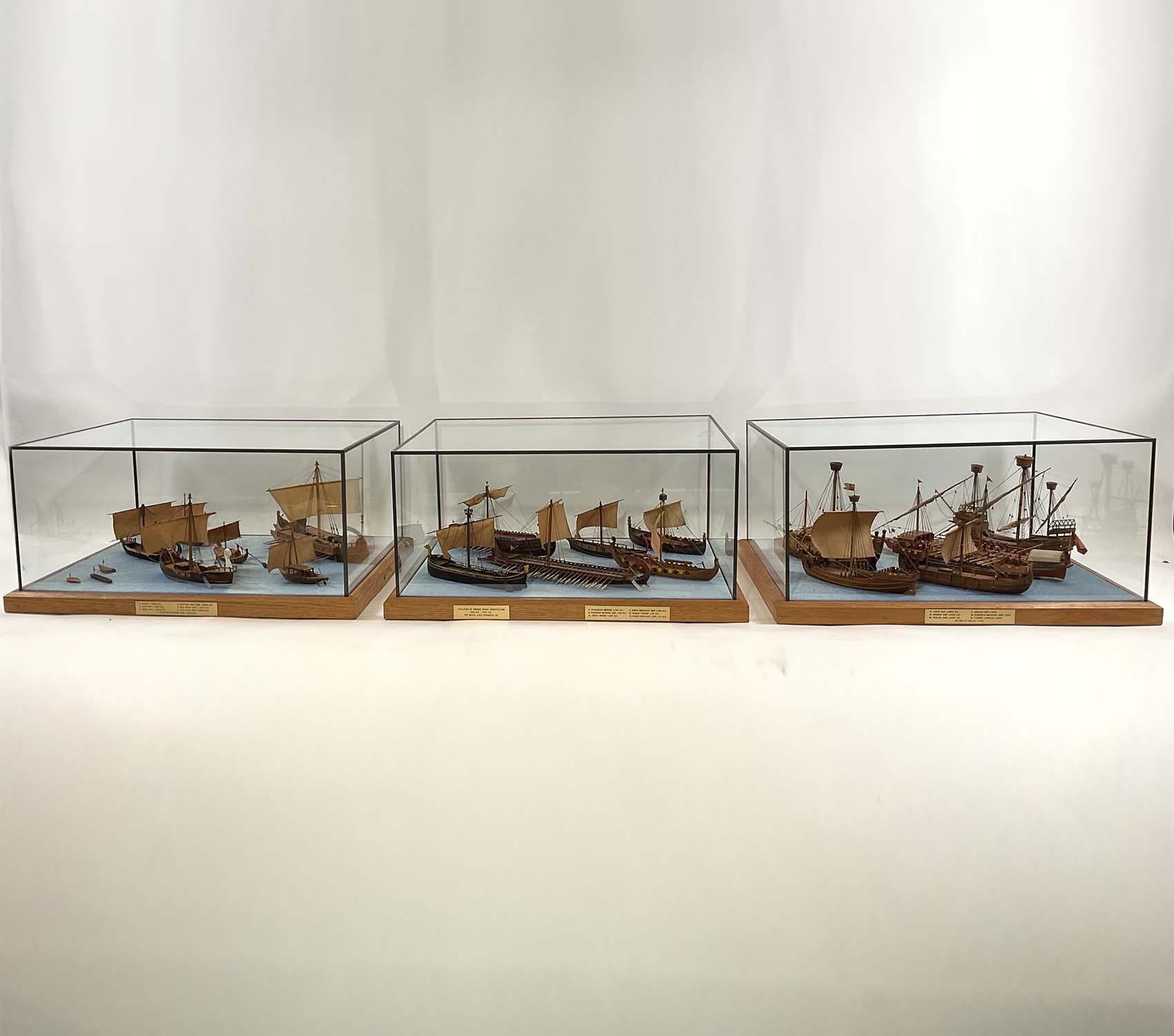 Three display cases of twenty 1/8 scale ancient naval models. Represents ships from the Evolution of Ancient Naval Architecture 750 BC - 1700 AD collection, 1/8th scale, E.A.R. Ronnberg, Sr. With gallery tag from the American Marine Model Gallery,