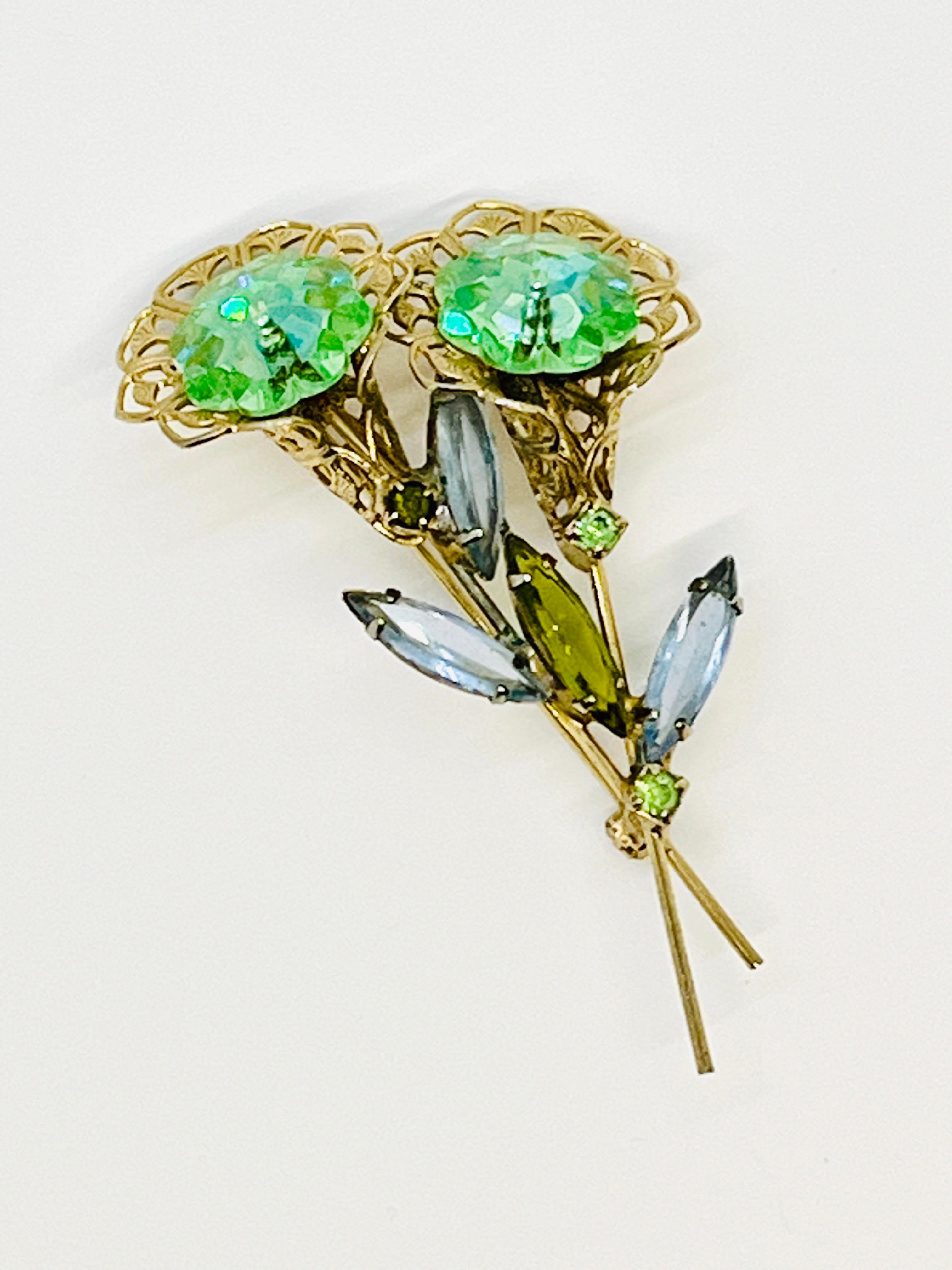 Twin Flower Aqua Margarita Crystal Stone, Olive green, Sky Blue, Elongated Navette Rhinestone Leaf Brooch, Golden Filagree trumpet flower detail. Two small brilliant cut mint green stones. Midcentury.

The Margarita cut crystals are brilliant, of