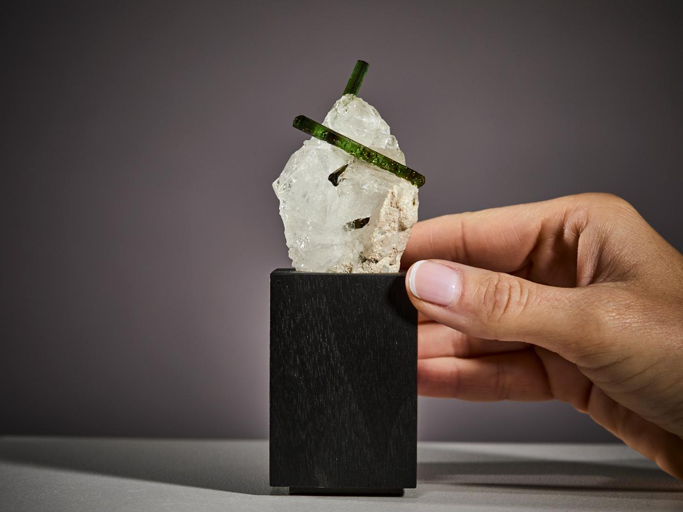 A striking composition of nature’s elegance, this beautiful specimen
features two rich green tourmaline crystals dramatically piercing through
a luminous white quartz matrix.

The contrast between the translucent, verdant tourmaline and the