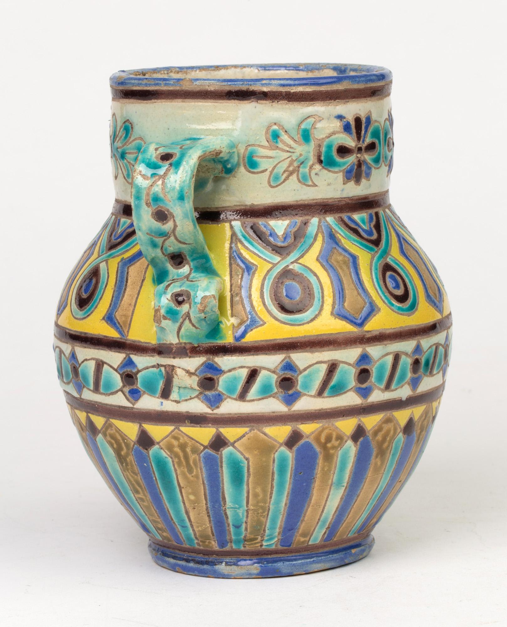 A stylish antique tin glazed twin handled pottery vase believed to be of Mediterranean, probably Spanish, origin but with Iznik style designs dating from the 19th century. The lightly potted vase is of urn shape with a narrow rounded foot, rounded
