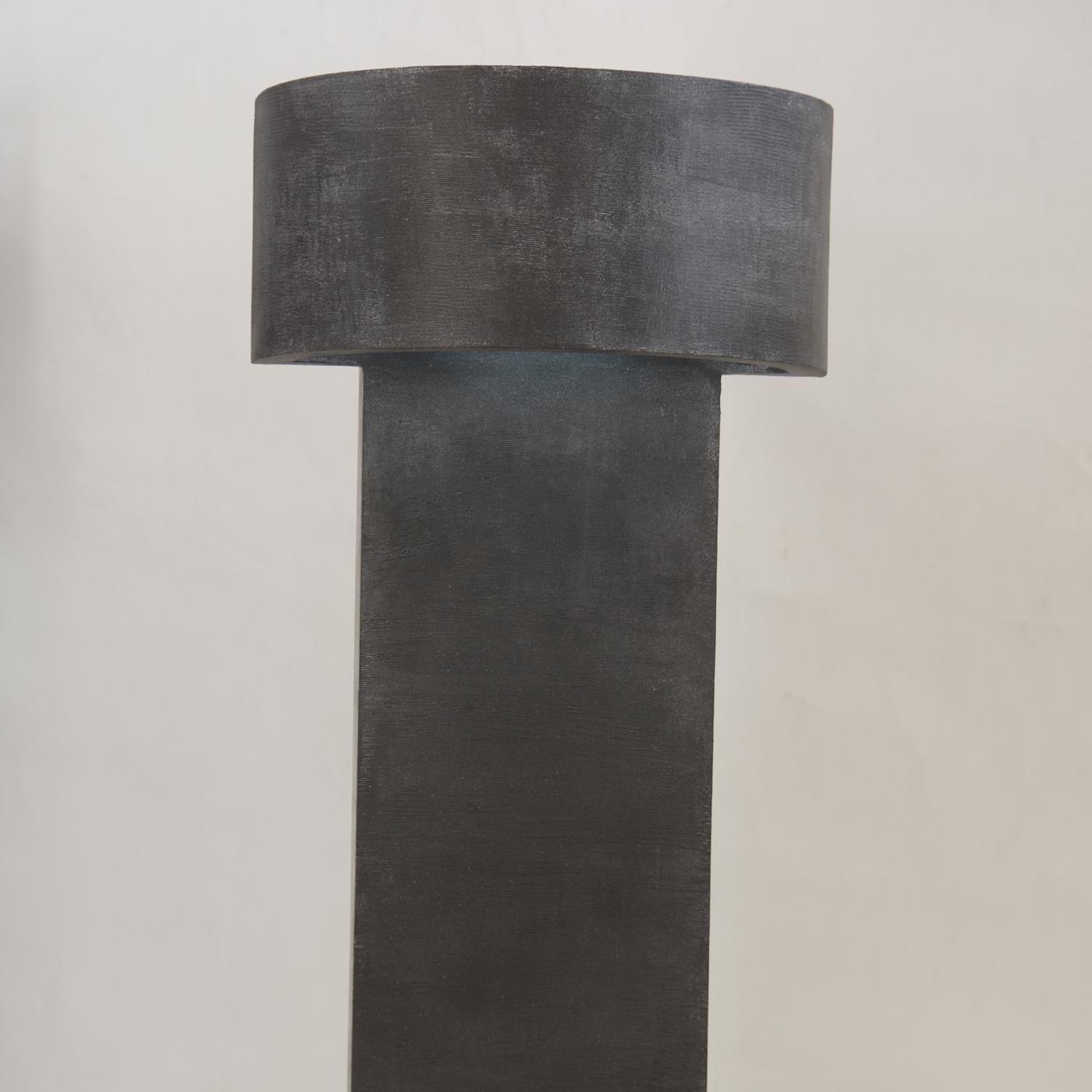 Part of the Monolith series, this lamp is defined by sleek lines and imposing proportions. Handcrafted of wood with a dark finish, the tall, vertical base is topped by a semi-circular 
