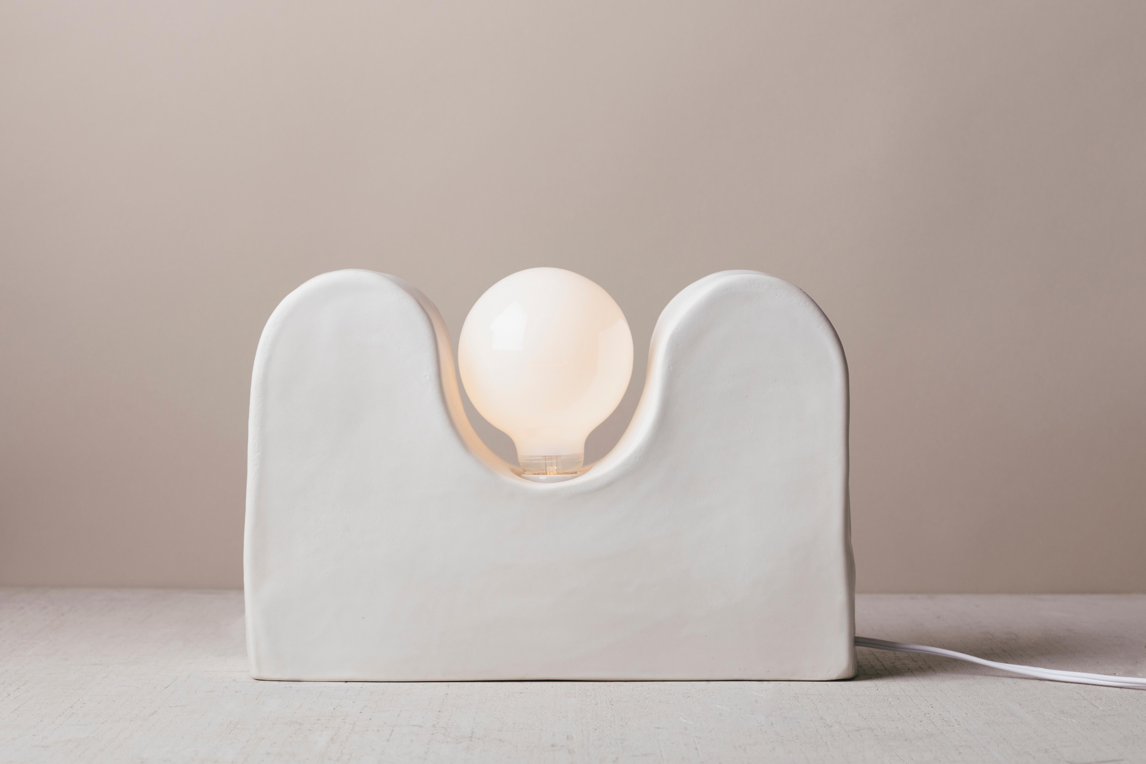From the Out West collection, our Twin Sisters table lamp is named after Twin Sisters Peak, Oregon. Made by hand out of Stoneware ceramics, glazed white, the design takes inspiration from the location's specific terrain while the light bulb