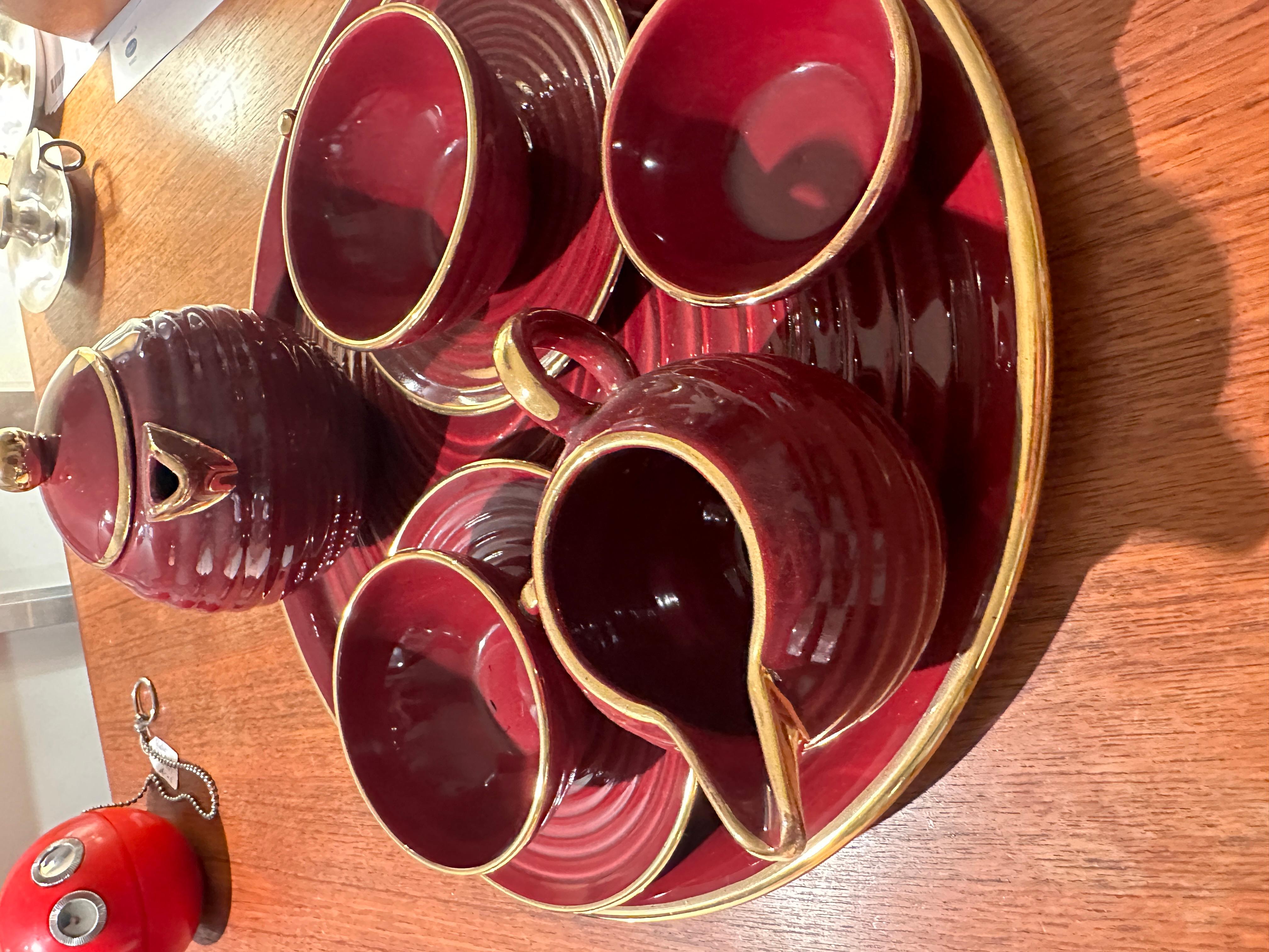 Very elegant tea set all pieces in ceramic Bordeaux and gold, by St Clement, including the round tray, two cups and 