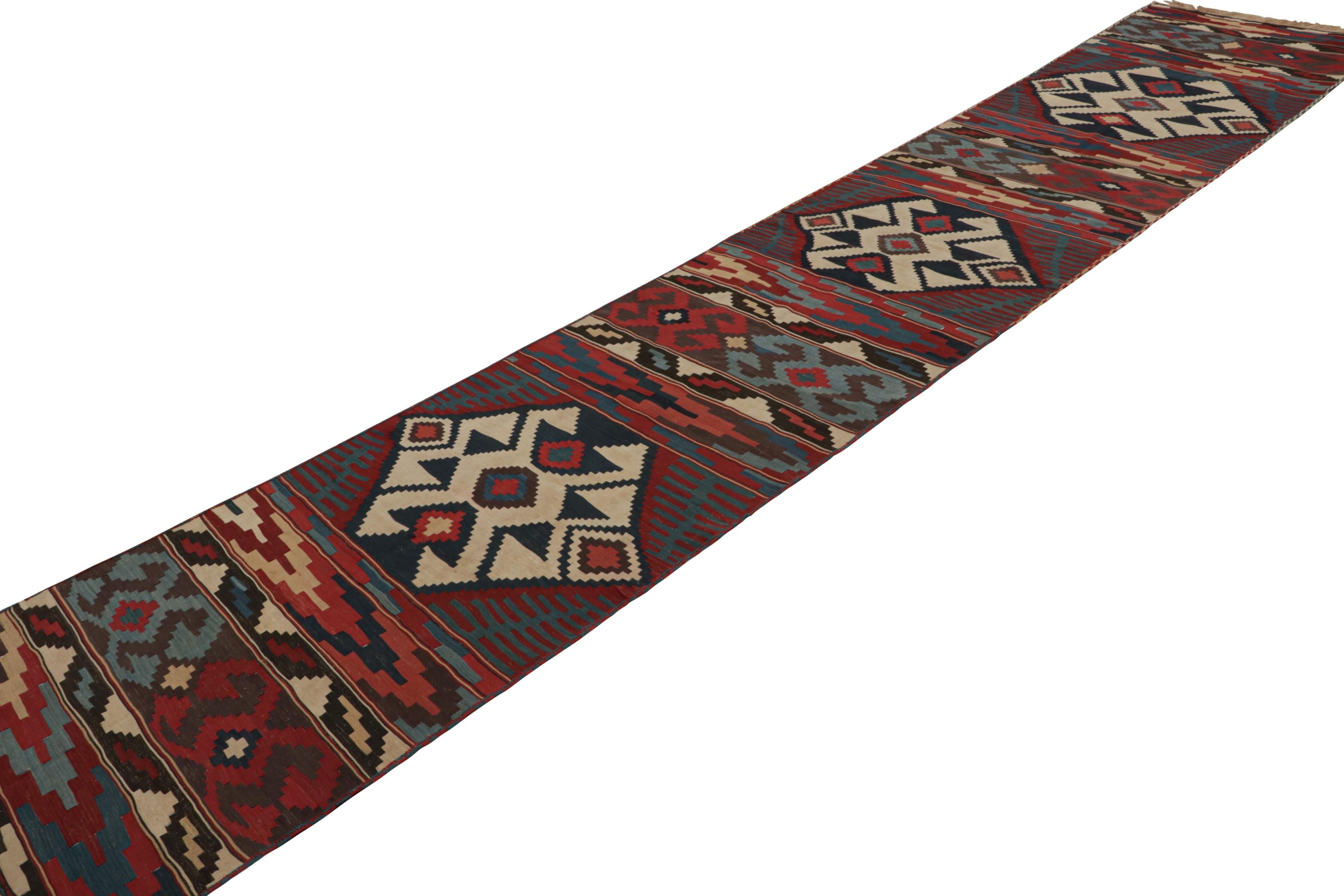 Dieses Flachgewebe stammt aus einem seltenen Paar von zwei persischen 3x17 Vintage-Kilim-Läufer-Teppichen, handgeknüpft in Wolle um 1950-1960. Diese Tribal-Läufer sind in Größe und Design nahezu identisch, mit geometrischen Mustern in Rot-, Blau-