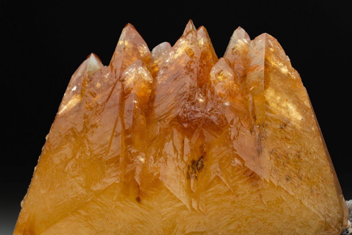 Large aesthetic scalenohedral formation of rich deep golden calcite crystals in a parallel formation on matrix embedded with metallic sphalerite crystals. The calcite has a gradience of  translucent to transparent at the termination, with lustrous