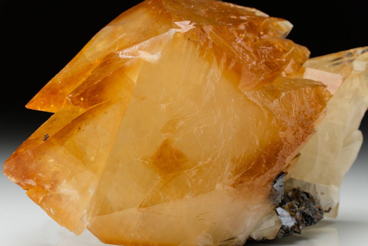 This Twinned Golden Calcite Crystal from Elmwood Mine, Tennessee weighs 3.5 lbs with dimensions of 7 x 3 x 3 inches. Its lustrous transparent deep golden color is complemented by a small sphalerite matrix. It is characterized by a large double