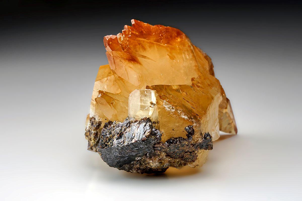 Lustrous transparent deep golden calcite crystal on matrix. Large double terminated scalenohedral twinned crystals with sub parallel growth faces. This stunning specimen is perfect for home or office décor, and its unique shape adds a touch of