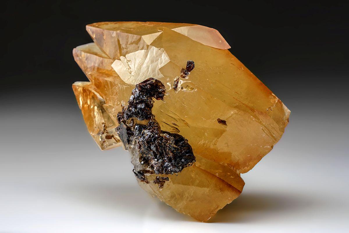 Lustrous transparent deep golden calcite crystal on matrix. Large double terminated scalenohedral twinned deep golden calcite crystals with inclusions of sphalertie. The twinning on the C-axis has well defined re-entrant faces. This particular