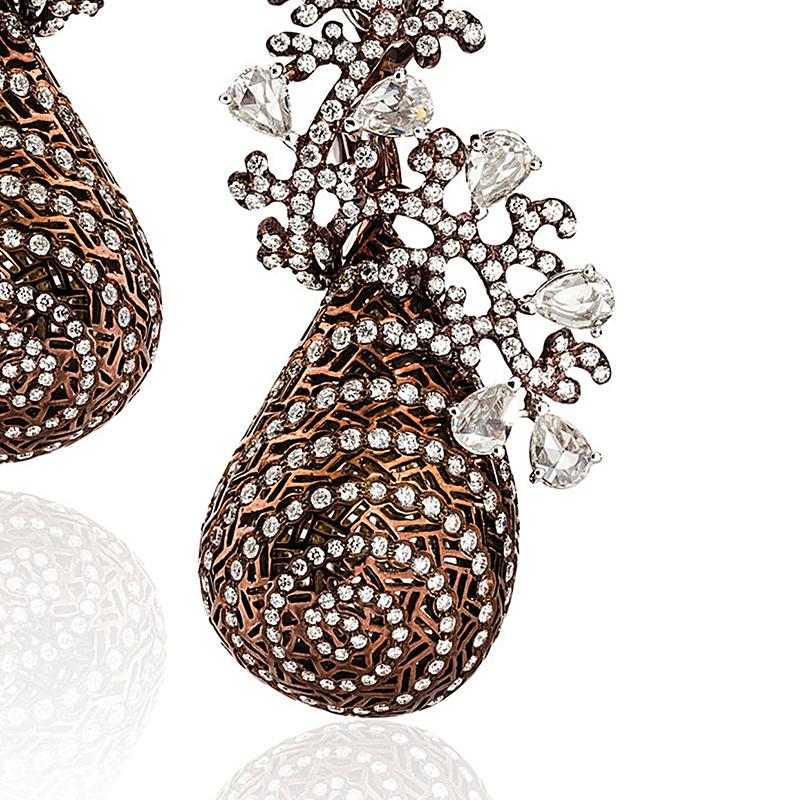 A pair of modern Twirling Shimmer earrings by Neha Dani. These earrings are 18 karat white gold and bronze rhodium and have a full tear-shape drop enlivened with radiating spiral patterning, striations of diamonds, textured bronze rhodium-plated